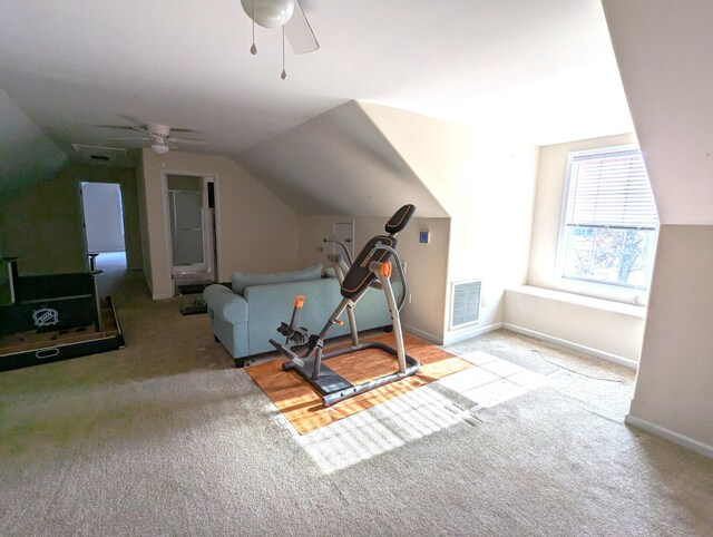 workout area with carpet floors, baseboards, visible vents, and vaulted ceiling