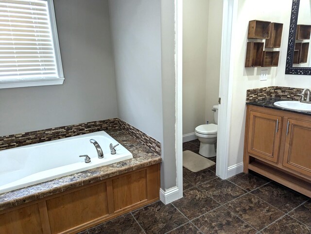 full bathroom featuring a garden tub, toilet, vanity, baseboards, and decorative backsplash