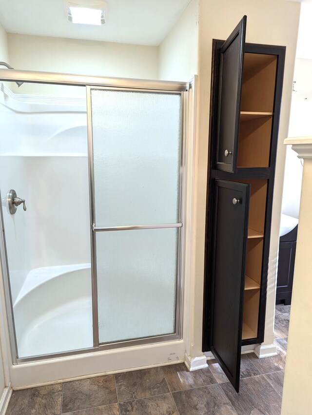 full bath with stone finish flooring and an enclosed shower