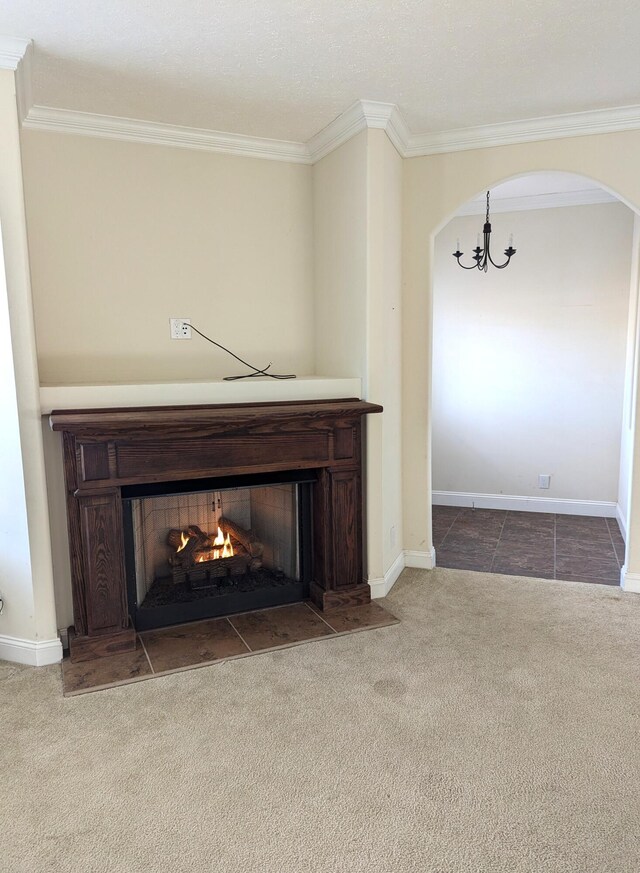 details featuring baseboards, arched walkways, a fireplace with flush hearth, crown molding, and carpet floors