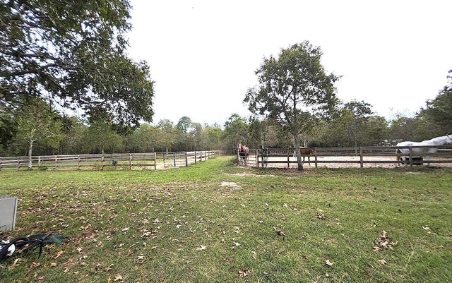 view of yard with a rural view and an enclosed area