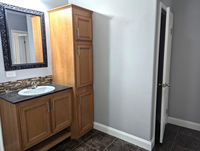 bathroom with tasteful backsplash, baseboards, and vanity