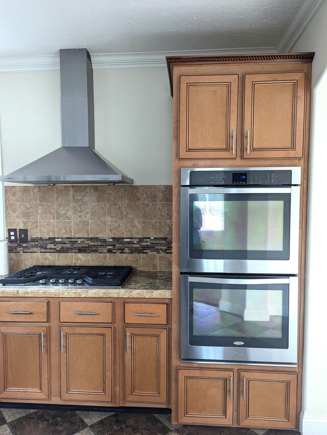 kitchen featuring wall chimney exhaust hood, ornamental molding, backsplash, and stainless steel appliances