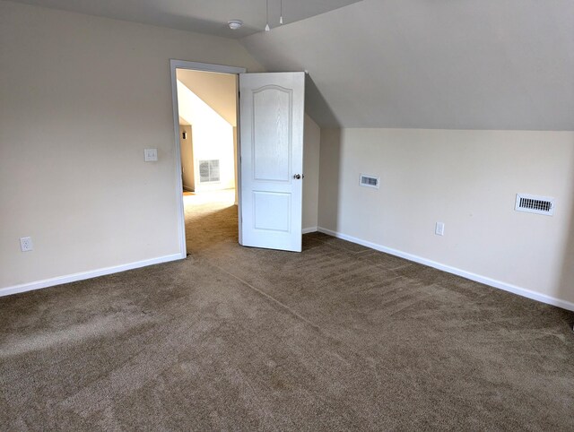 bonus room with baseboards, vaulted ceiling, visible vents, and dark colored carpet