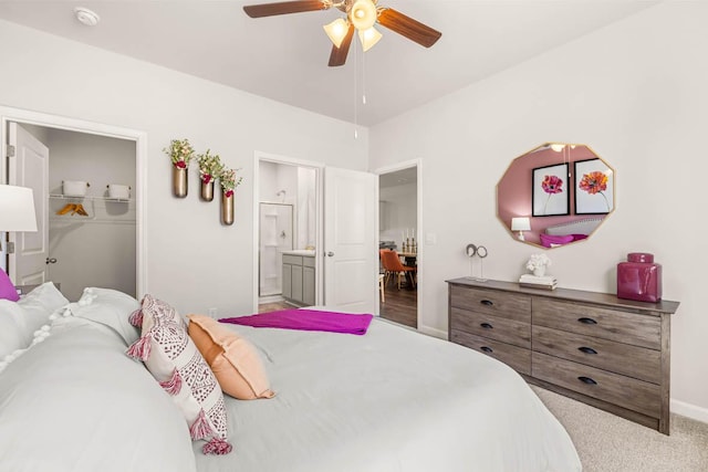 bedroom featuring connected bathroom, ceiling fan, carpet floors, a walk in closet, and a closet