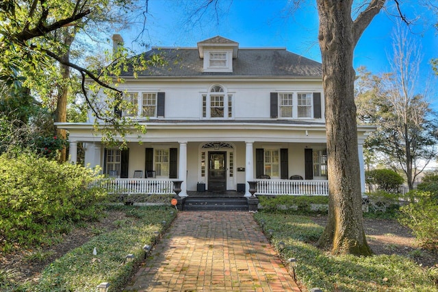 traditional style home with covered porch and stucco siding