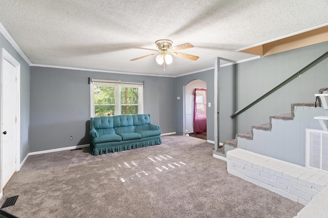 5950 E Ga Highway 24, Louisville, GA 30434 - carpeted living room featuring crown molding, arched walkways, ceiling fan, stairs, and baseboards
