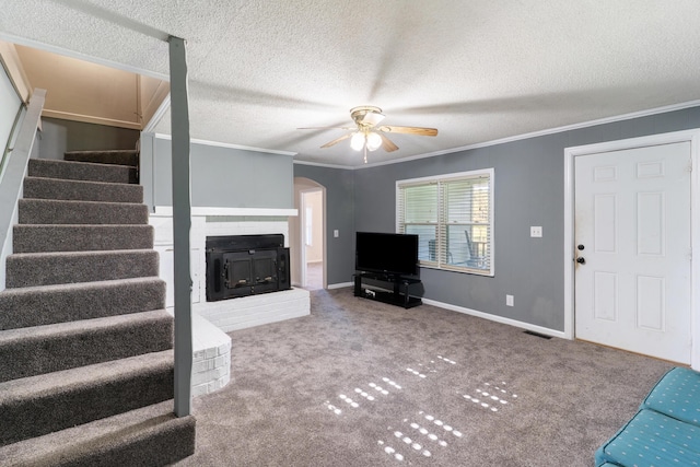 5950 E Ga Highway 24, Louisville, GA 30434 - unfurnished living room with ornamental molding, stairs, a ceiling fan, carpet flooring, and a glass covered fireplace