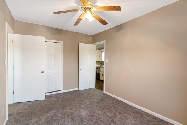 5950 E Ga Highway 24, Louisville, GA 30434 - unfurnished bedroom featuring dark colored carpet, a closet, baseboards, and a ceiling fan