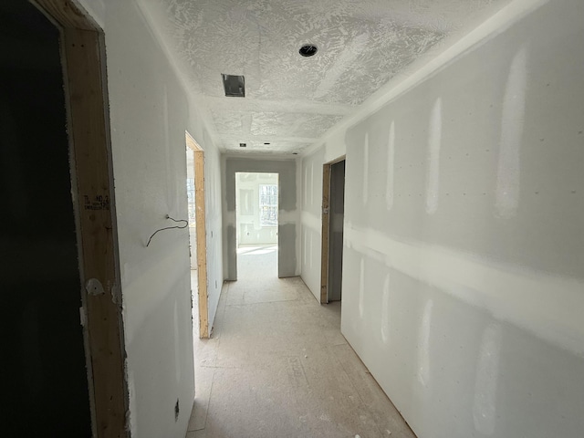 hallway with a textured ceiling