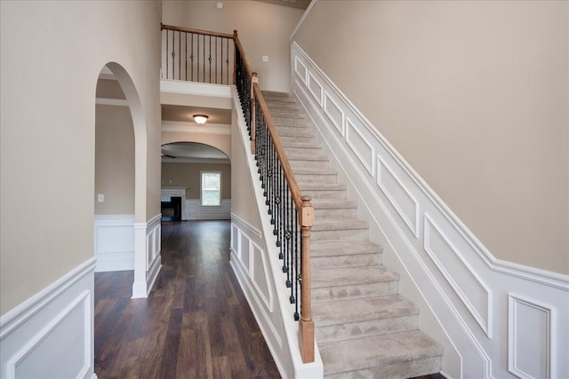 2083 Willhaven Dr, Augusta, GA 30909 - stairs with wainscoting, wood finished floors, arched walkways, a decorative wall, and a fireplace