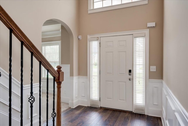 2083 Willhaven Dr, Augusta, GA 30909 - foyer entrance with arched walkways, dark wood finished floors, a wainscoted wall, a decorative wall, and stairs