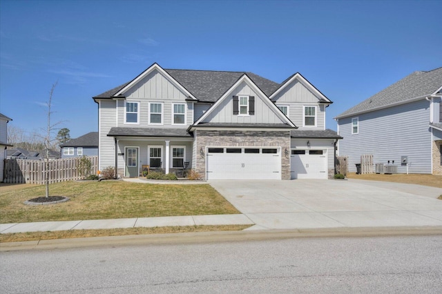 craftsman house featuring an attached garage, central air condition unit, fence, board and batten siding, and a front yard