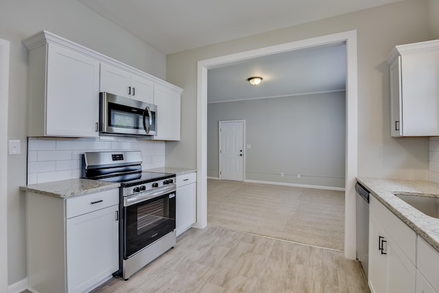 807 Crawford Ave, Augusta, GA 30904 - kitchen with stainless steel appliances, tasteful backsplash, white cabinetry, light stone countertops, and baseboards