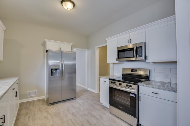 807 Crawford Ave, Augusta, GA 30904 - kitchen featuring stainless steel appliances, baseboards, backsplash, white cabinets, and light stone countertops