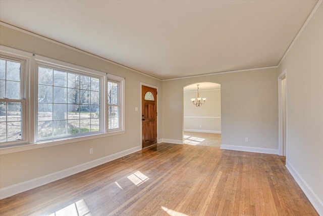 foyer entrance featuring ornamental molding, a chandelier, and light hardwood / wood-style flooring