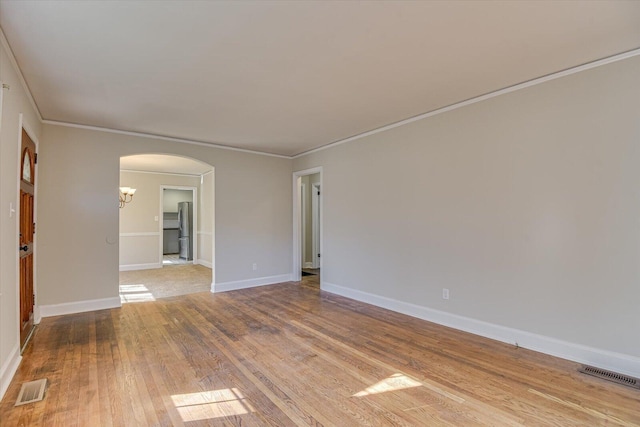 empty room featuring crown molding and light hardwood / wood-style floors