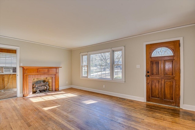 unfurnished living room with hardwood / wood-style floors and crown molding