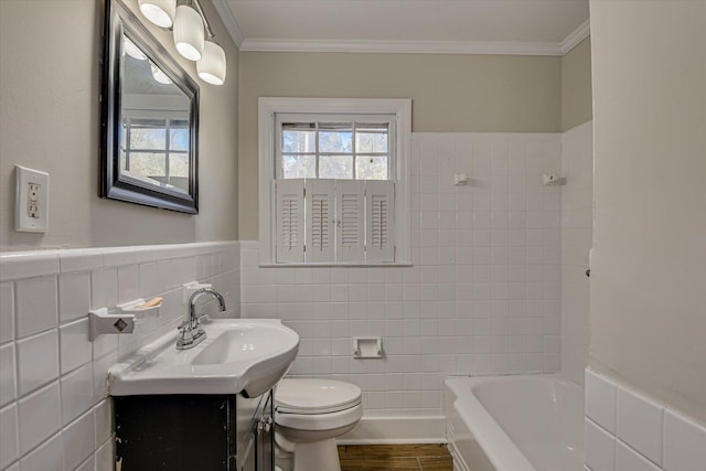 bathroom featuring tile walls, ornamental molding, vanity, toilet, and a bath