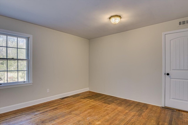 unfurnished room with a healthy amount of sunlight and wood-type flooring