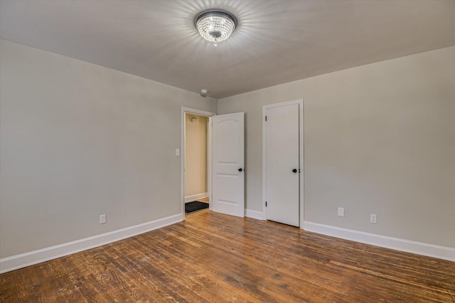 unfurnished room featuring dark wood-type flooring