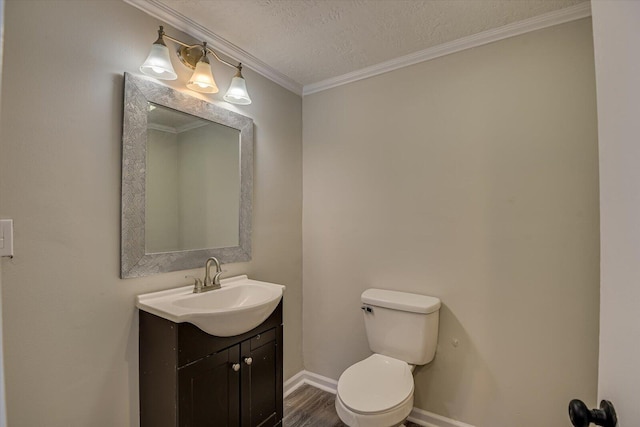 bathroom featuring crown molding, hardwood / wood-style flooring, vanity, a textured ceiling, and toilet