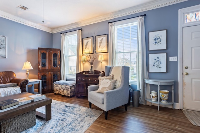 living room featuring visible vents, wood finished floors, and ornamental molding