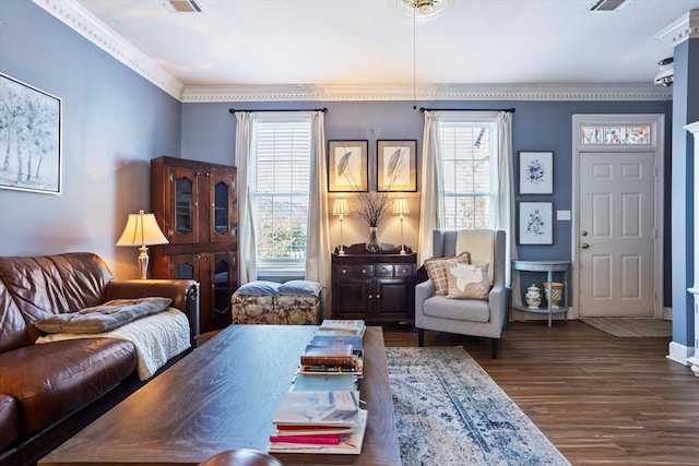 living room with visible vents, crown molding, baseboards, and wood finished floors