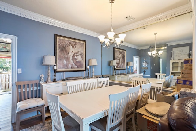 dining room featuring a chandelier, ornamental molding, wood finished floors, and visible vents