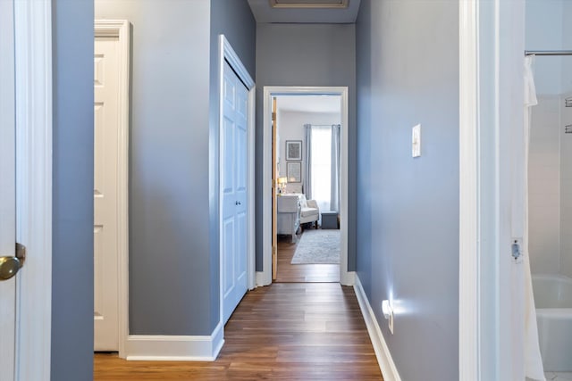 hallway with wood finished floors and baseboards