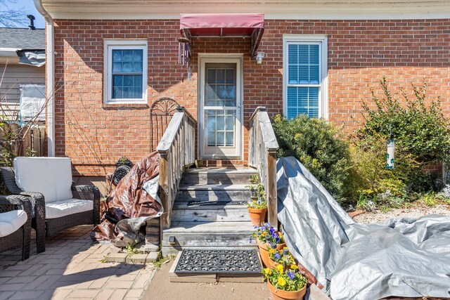 view of exterior entry featuring brick siding