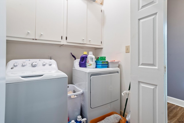 laundry area featuring independent washer and dryer, wood finished floors, cabinet space, and baseboards