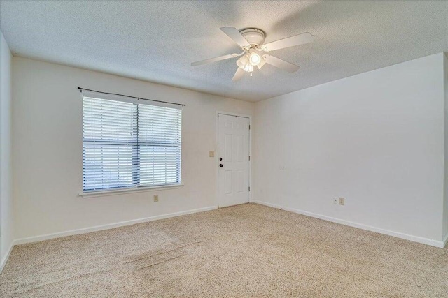 carpeted spare room with ceiling fan and a textured ceiling