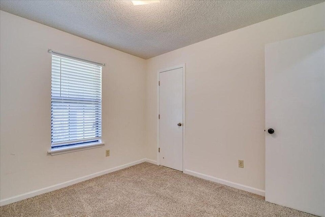 carpeted spare room with a textured ceiling