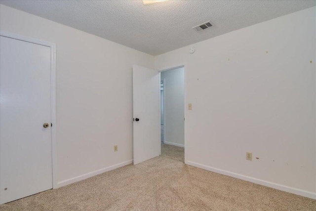 carpeted spare room featuring a textured ceiling