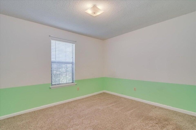 carpeted empty room featuring a textured ceiling