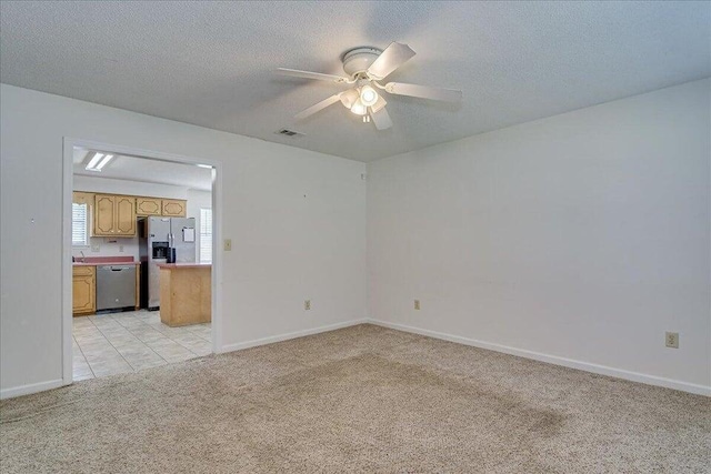 carpeted empty room featuring a textured ceiling and ceiling fan