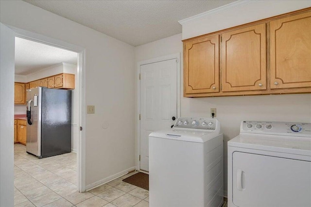 clothes washing area with cabinets, independent washer and dryer, a textured ceiling, and light tile patterned floors