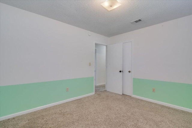 spare room with carpet and a textured ceiling