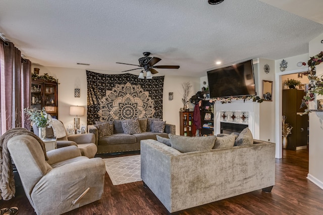 living room with dark hardwood / wood-style floors, ceiling fan, and a textured ceiling