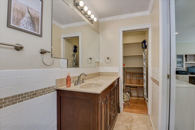 2408 Forest Park Rd, Augusta, GA 30904 - bathroom featuring vanity, ornamental molding, wainscoting, tile walls, and a spacious closet