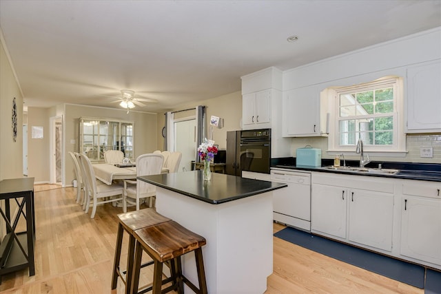 2408 Forest Park Rd, Augusta, GA 30904 - kitchen featuring dishwasher, a sink, oven, dark countertops, and light wood finished floors