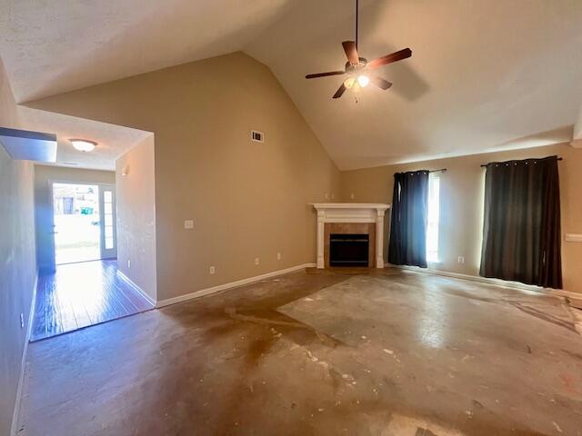 510 Lory Ln, Grovetown, GA 30813 - unfurnished living room featuring unfinished concrete floors, a ceiling fan, lofted ceiling, a fireplace, and baseboards