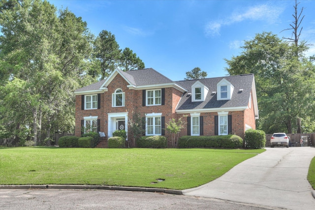 819 Cape Cod Ct, Evans, GA 30809 - colonial-style house with a front yard, brick siding, concrete driveway, and a shingled roof