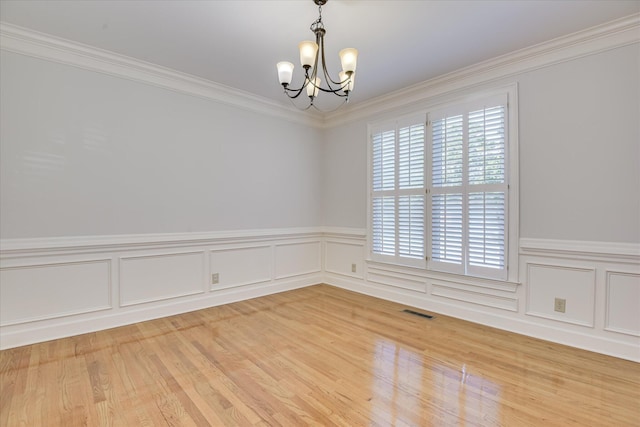 819 Cape Cod Ct, Evans, GA 30809 - empty room featuring a chandelier, a wainscoted wall, ornamental molding, light wood finished floors, and a decorative wall