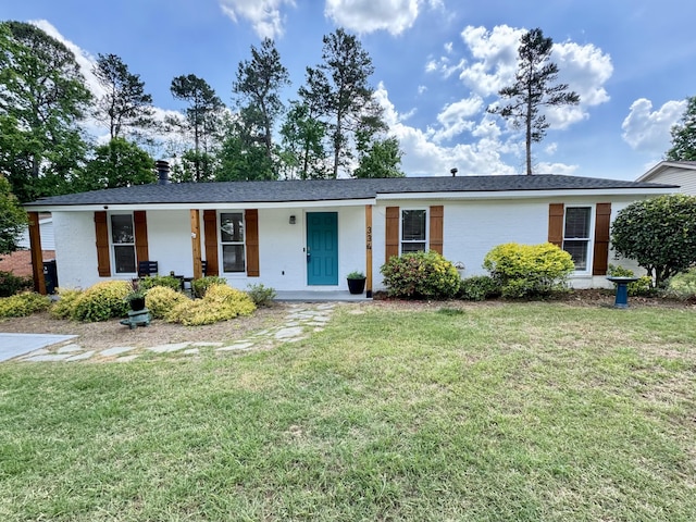 single story home featuring a porch, brick siding, and a front yard