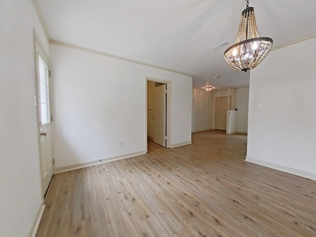 unfurnished room with baseboards, light wood finished floors, a chandelier, and visible vents