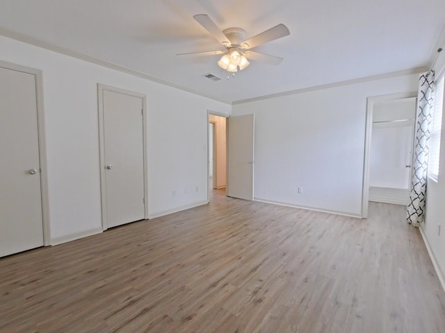 unfurnished bedroom featuring a ceiling fan, visible vents, baseboards, two closets, and light wood-style flooring