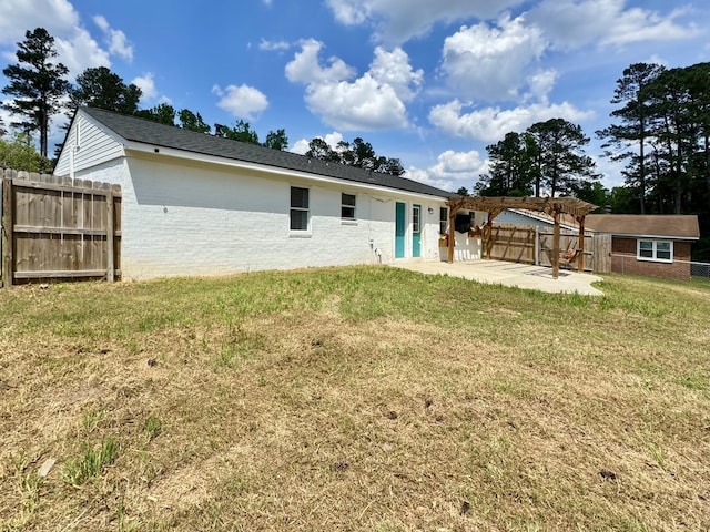 rear view of house with a lawn, a patio, an outdoor structure, a fenced backyard, and a pergola