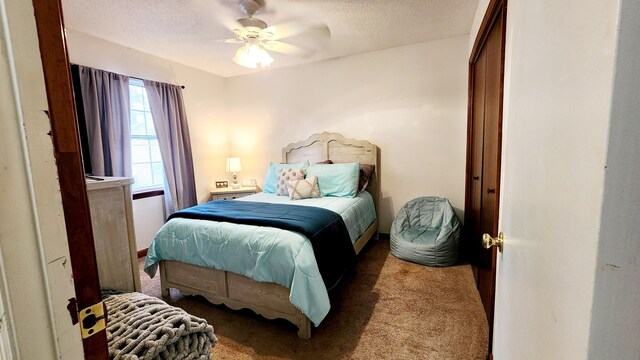 carpeted bedroom featuring a textured ceiling and a ceiling fan